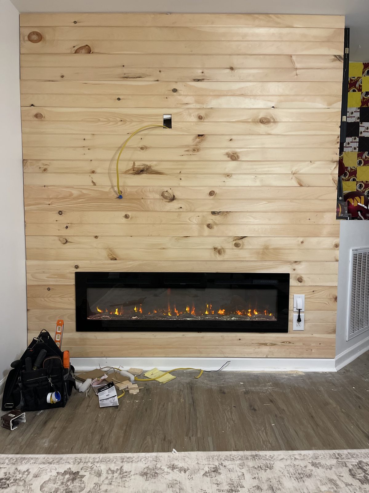 Pine accent wall + electric fireplace install (in progress).